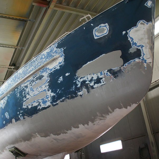 Preparation of the yacht paintwork by sandblasting the hull